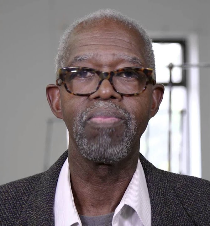 Sculptor and musician Malcolm Mooney gazes at the viewer in a tight close-up portrait