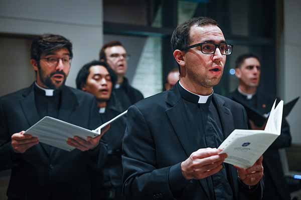 A group of young six Jesuits sing during a service.