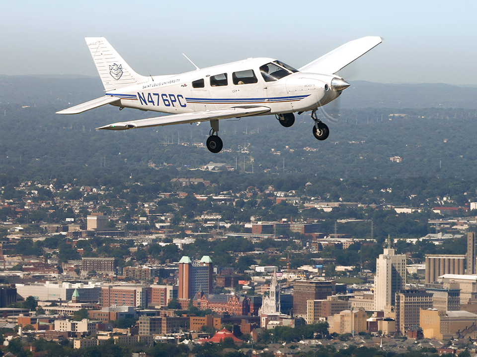 Piper Archer flying over campus